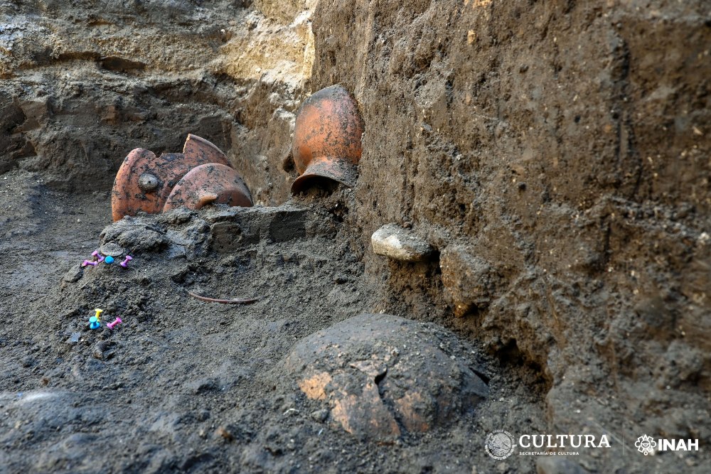 La investigadora resalta el hallazgo de un entierro infantil en uno de los perfiles del pozo. Foto: Melitón Tapia. INAH